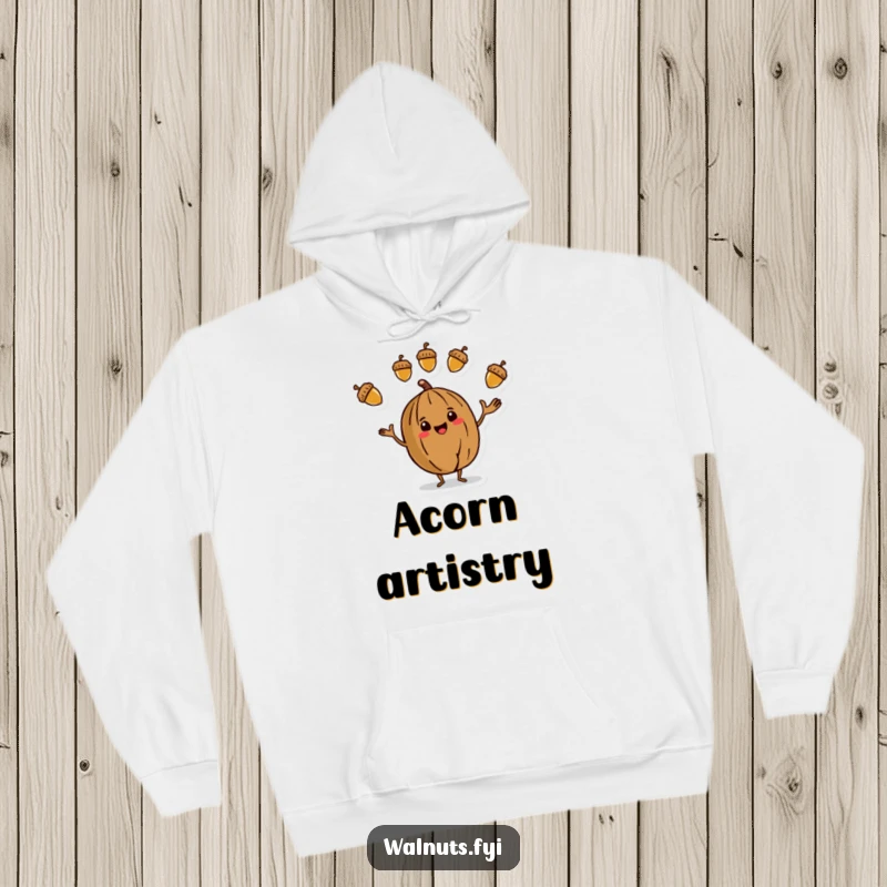 Funny Hoodie featuring a stylized walnut character in the act of juggling three vibrant acorns, looking skilled and cheerful.