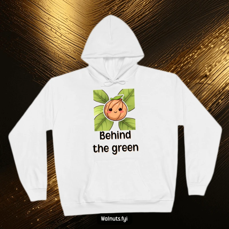 Funny hoodie featuring a bashful walnut character peeking from behind a leaf, offering cozy vibes.